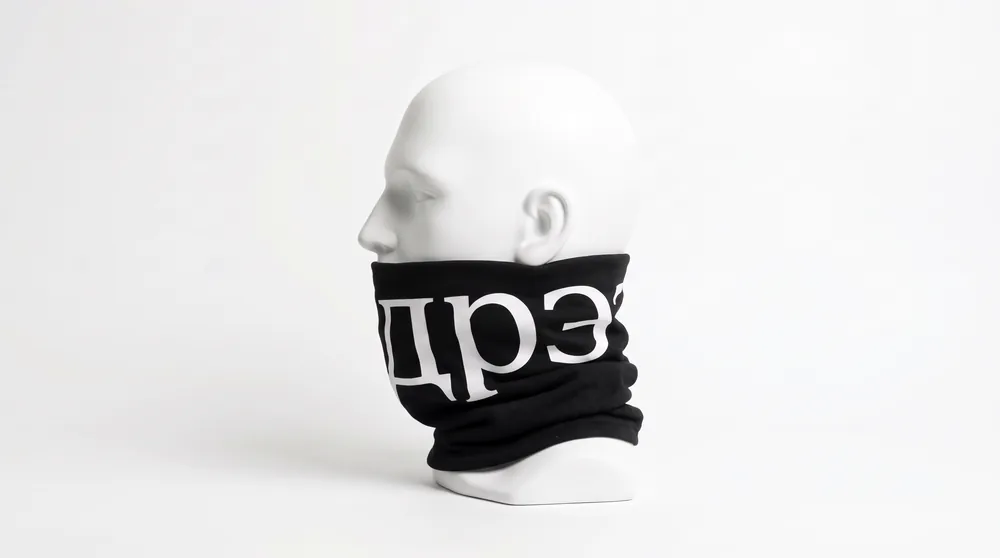 Black neck gaiter on a white mannequin, side view, with the дрЭ wordmark in white. Concept image.